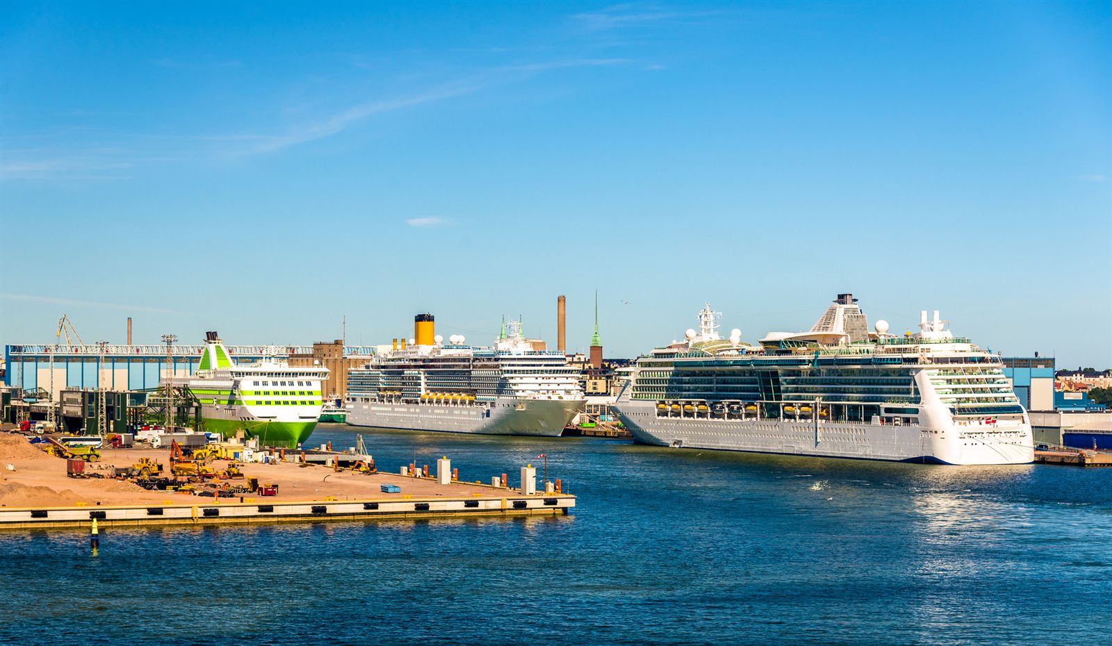 Several cruise ships tied up along a sunny Scandinavian cruise pier